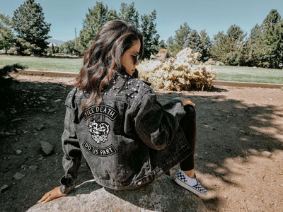 Person wearing a studded jacket with a unique design outdoors